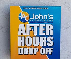 Box for John's Automotive Care after-hours drop-off. Blue and gold, text reads 