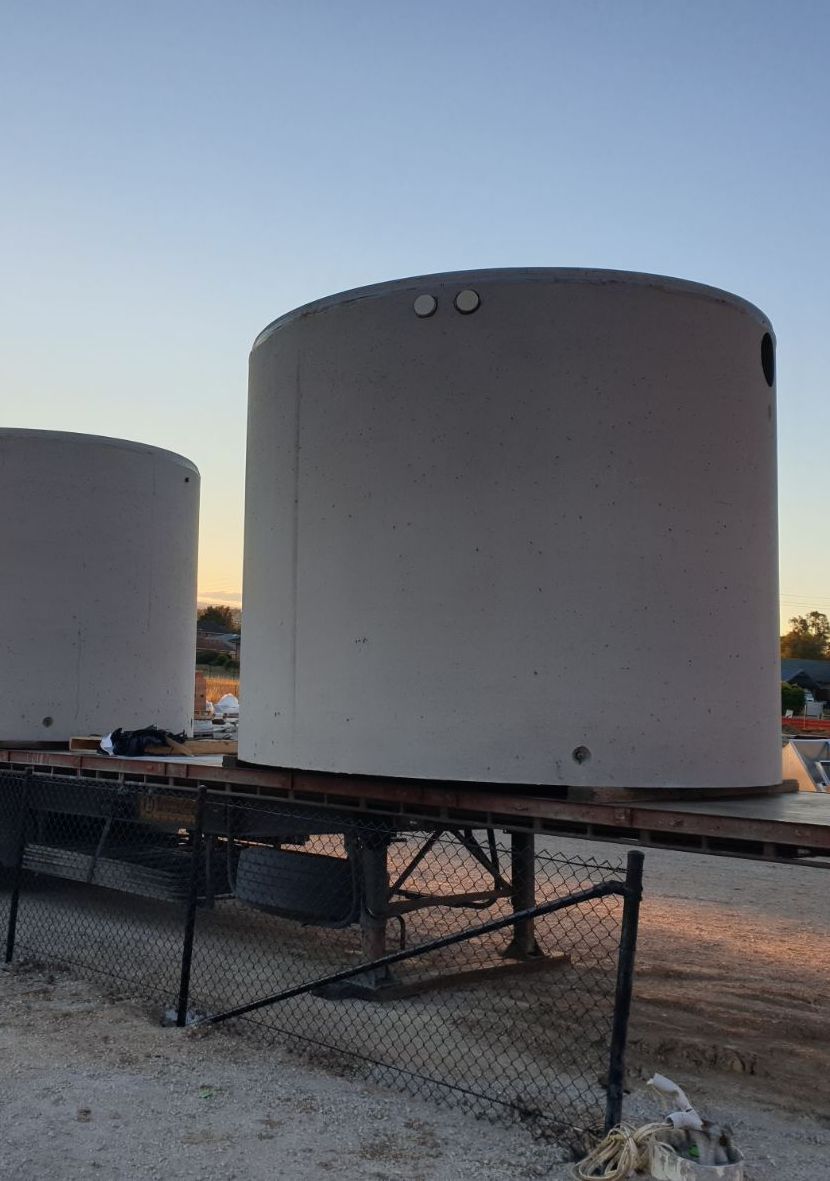 two large concrete tanks are sitting on top of a trailer .