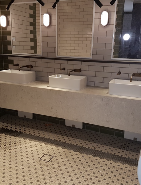 a bathroom with three sinks and two mirrors