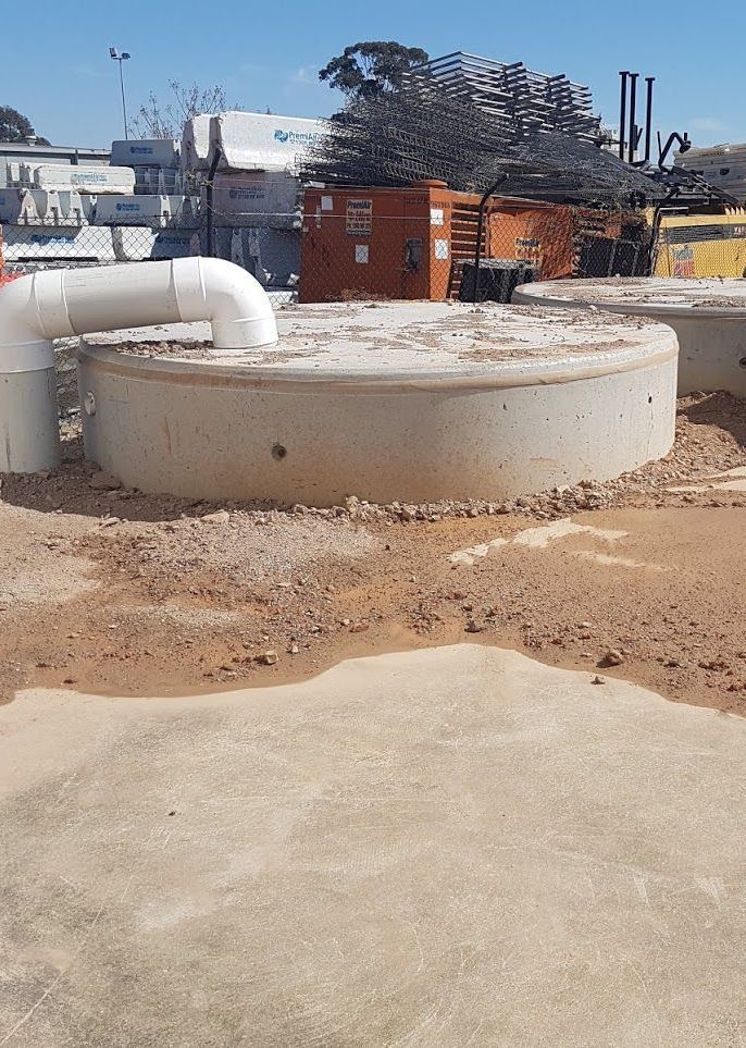 a concrete tank with a white pipe coming out of it