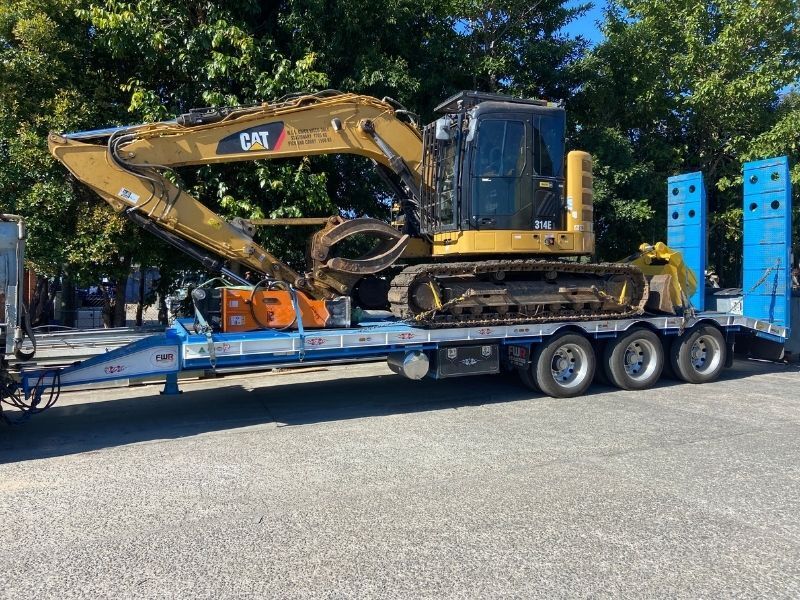 Digger on a trailer — Allcoast Group Demolition Contractors from About Us in Sunshine Coast, QLD