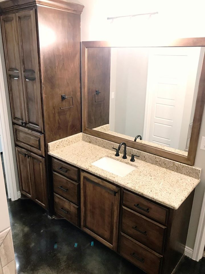 Bathroom with dark wood cabinets, a light countertop, and a large mirror.