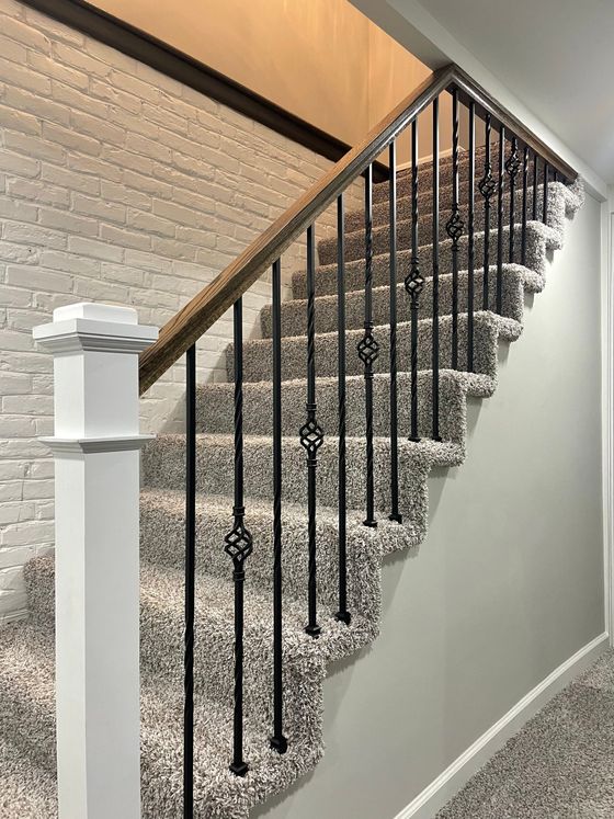 A staircase with a black railing and a carpeted floor.