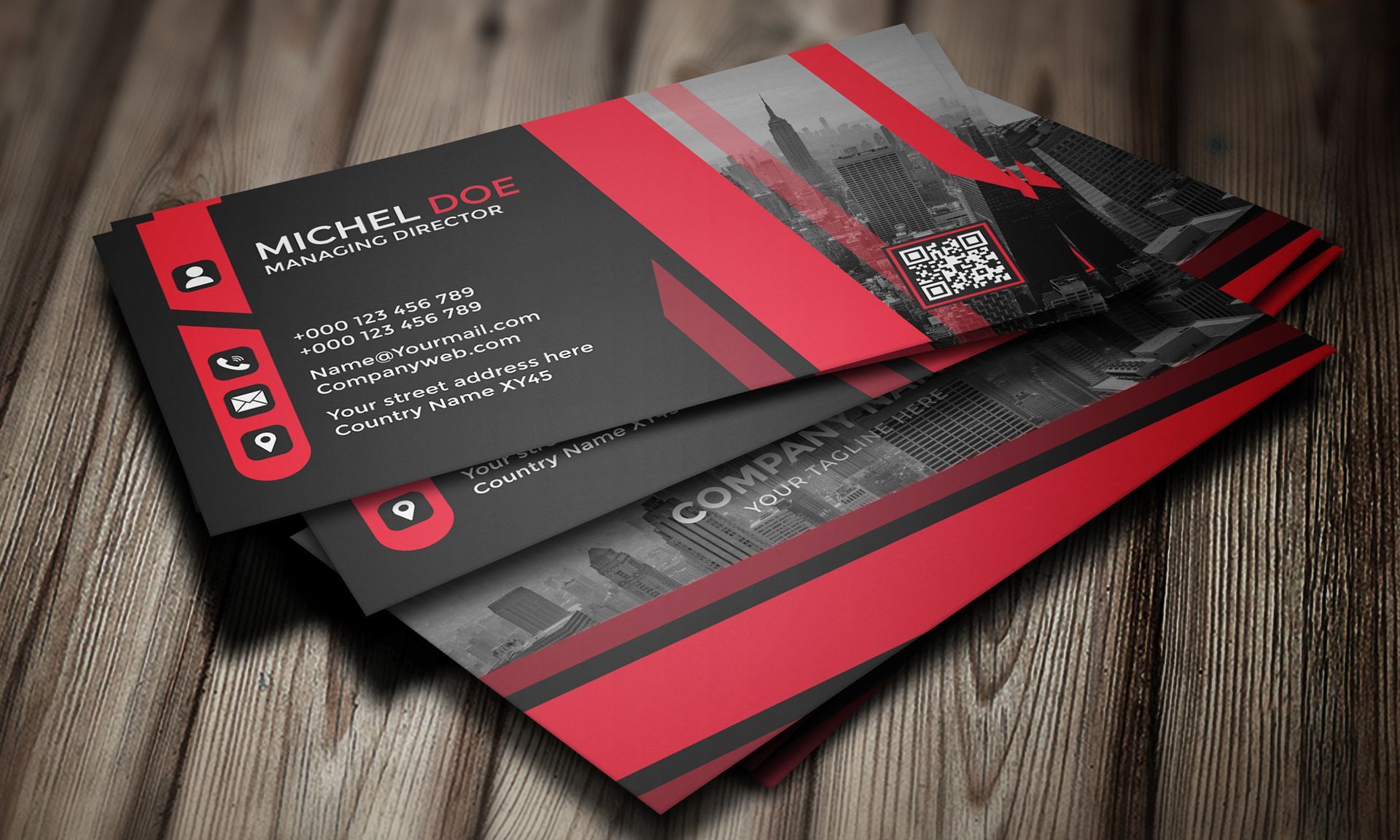 Stack of custom printed business cards with a modern red and black design displayed on a surface.