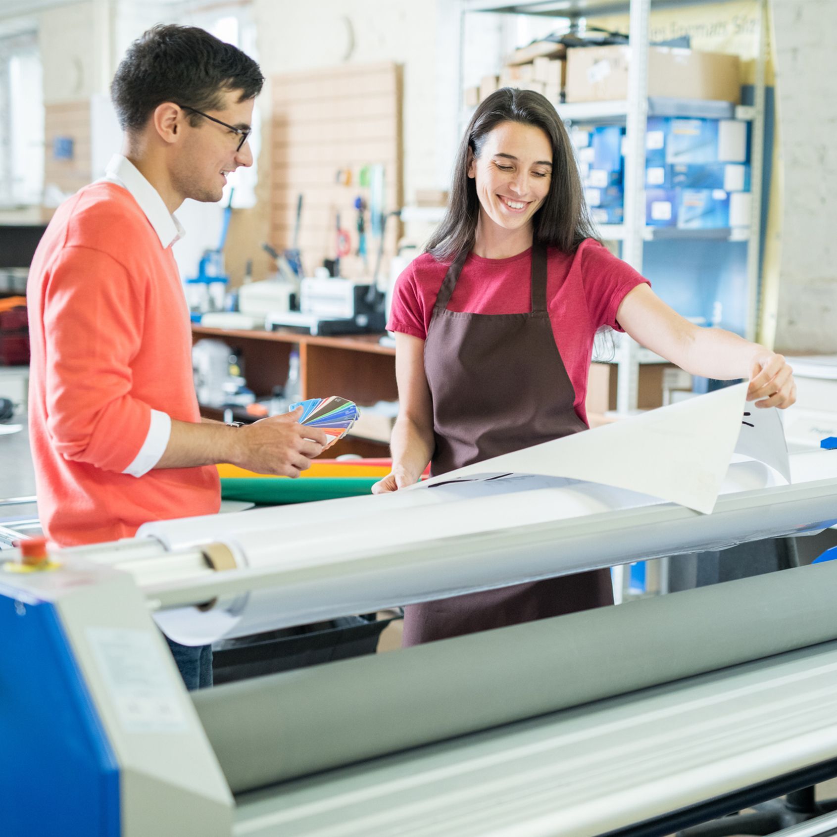 Woman showing custom-printed banner to customer Woman showing custom-printed banner to customer