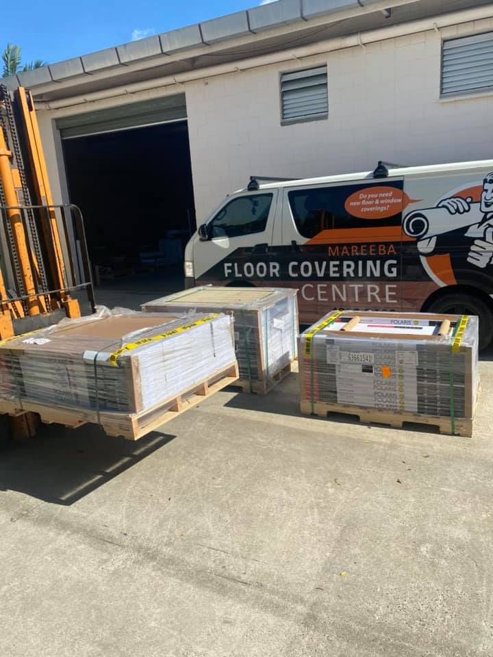 Three Pallets Of Flooring Materials Near A Building And A Branded Van — Mareeba Floor Covering Centre in Mareeba, QLD