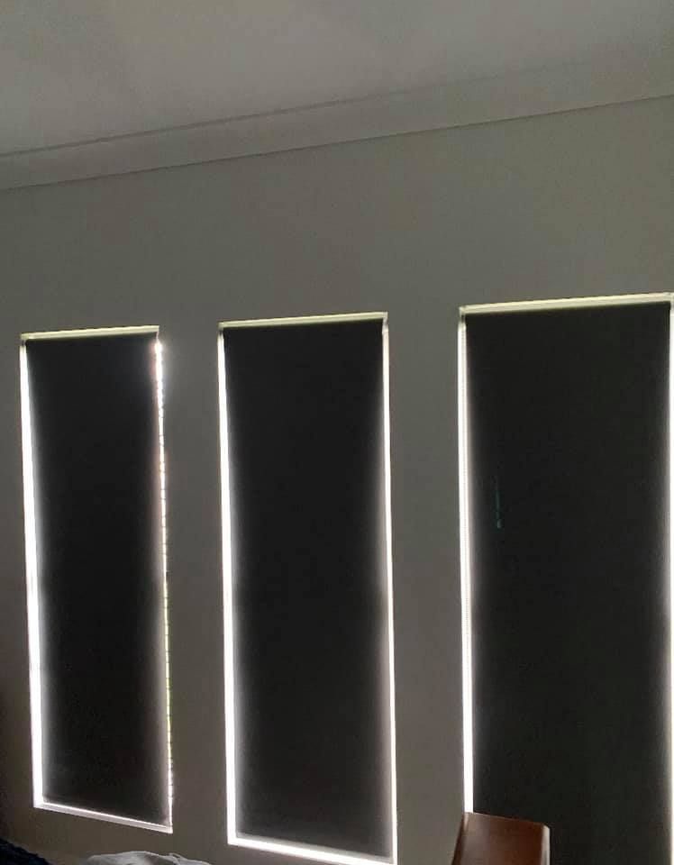 Three Dark Roller Blinds In A Row On A Light-colored Wall — Mareeba Floor Covering Centre in Cooktown, QLD