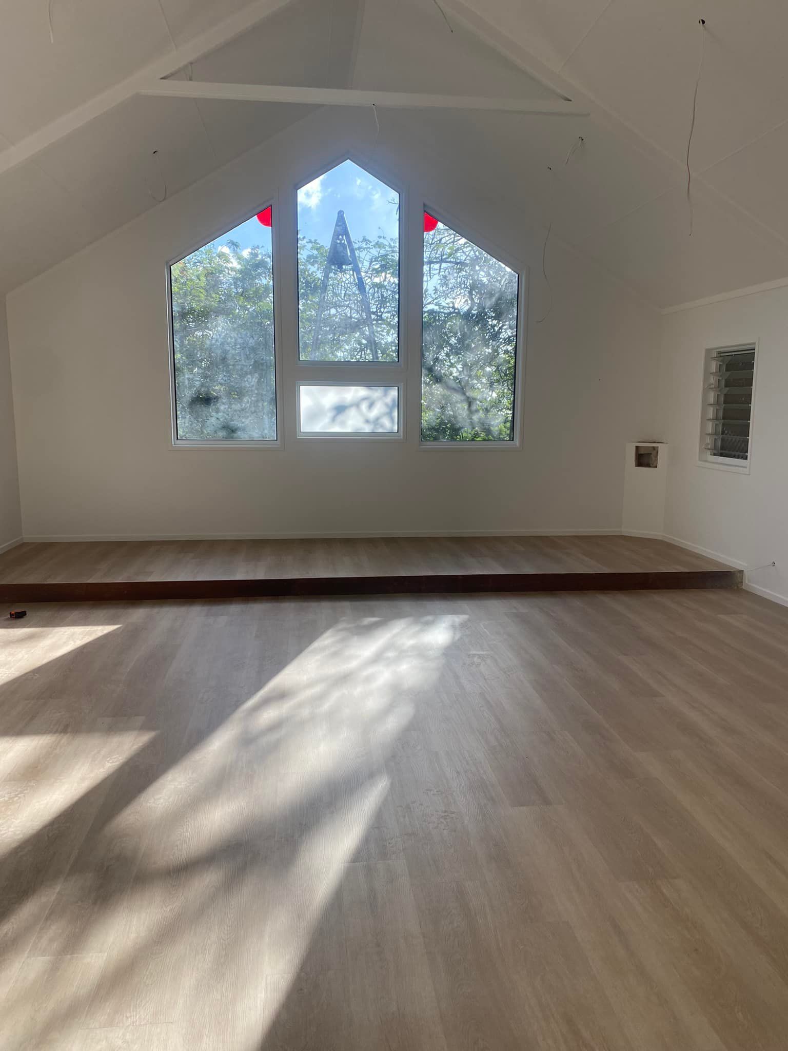Interior room with wood floor, platform, and arched window — Mareeba Floor Covering Centre in Mareeba, QLD