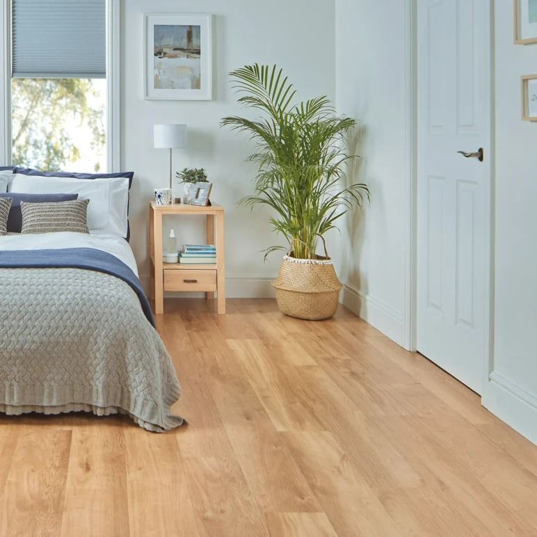 Bedroom with wood floor, bed with blue and gray bedding — Mareeba Floor Covering Centre in Cooktown, QLD