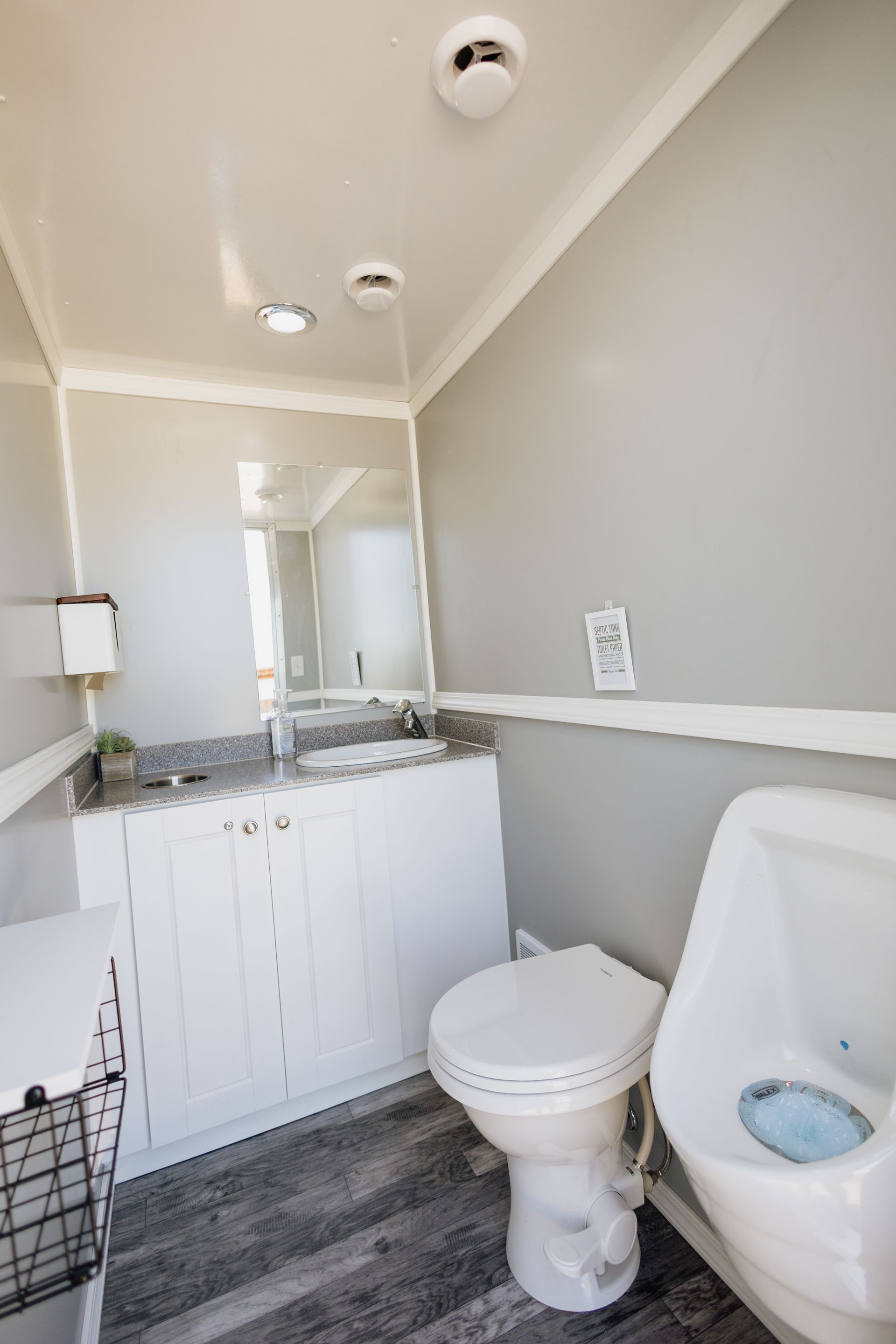 Small bathroom with a white toilet, sink vanity, and gray walls and flooring.