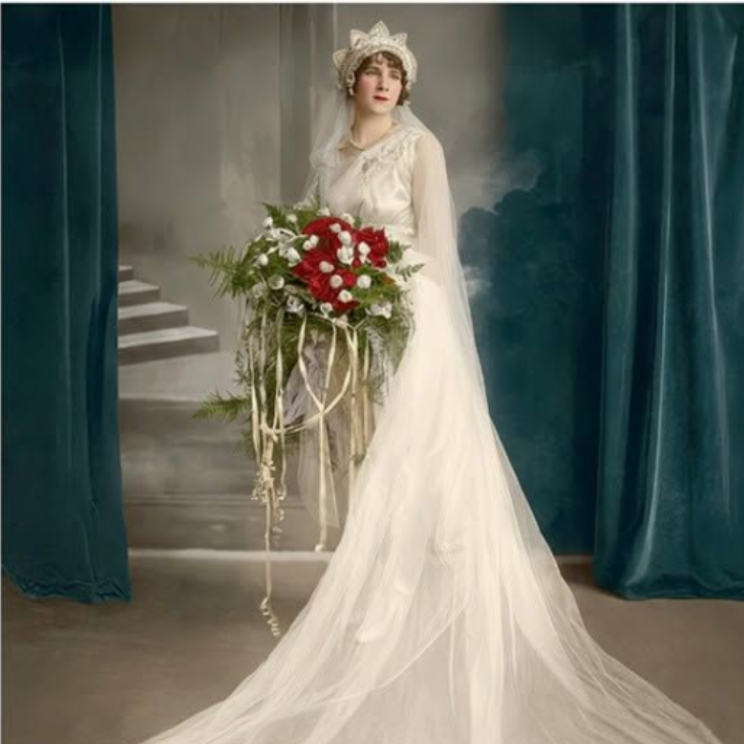 Bridal figure in a white gown and veil holding a red-and-white bouquet beside teal curtains and stairs