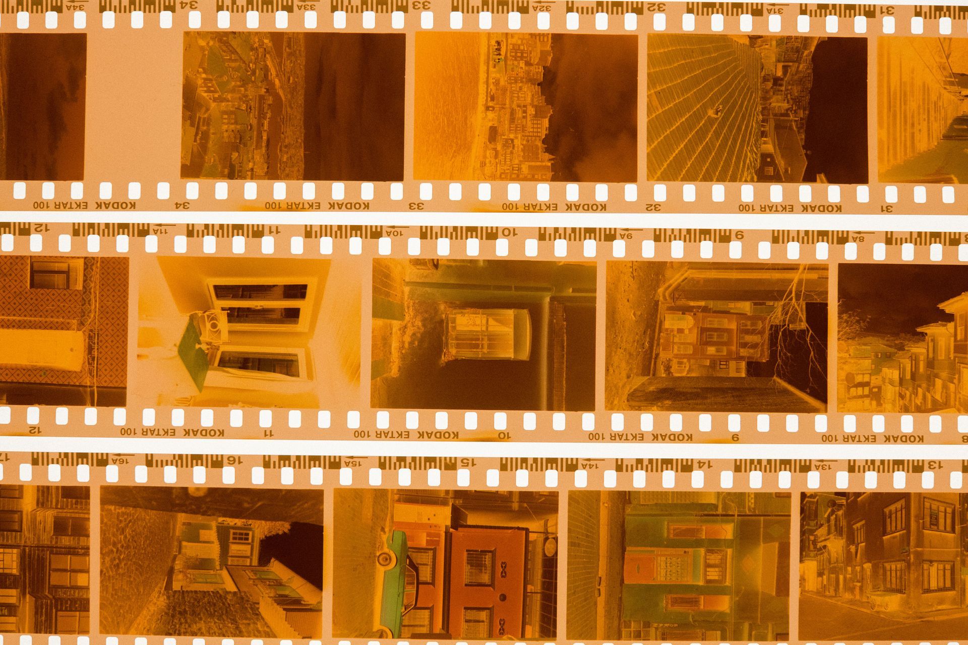 Orange-tinted aerial view of a city block with rooftops and a road cutting across the frame