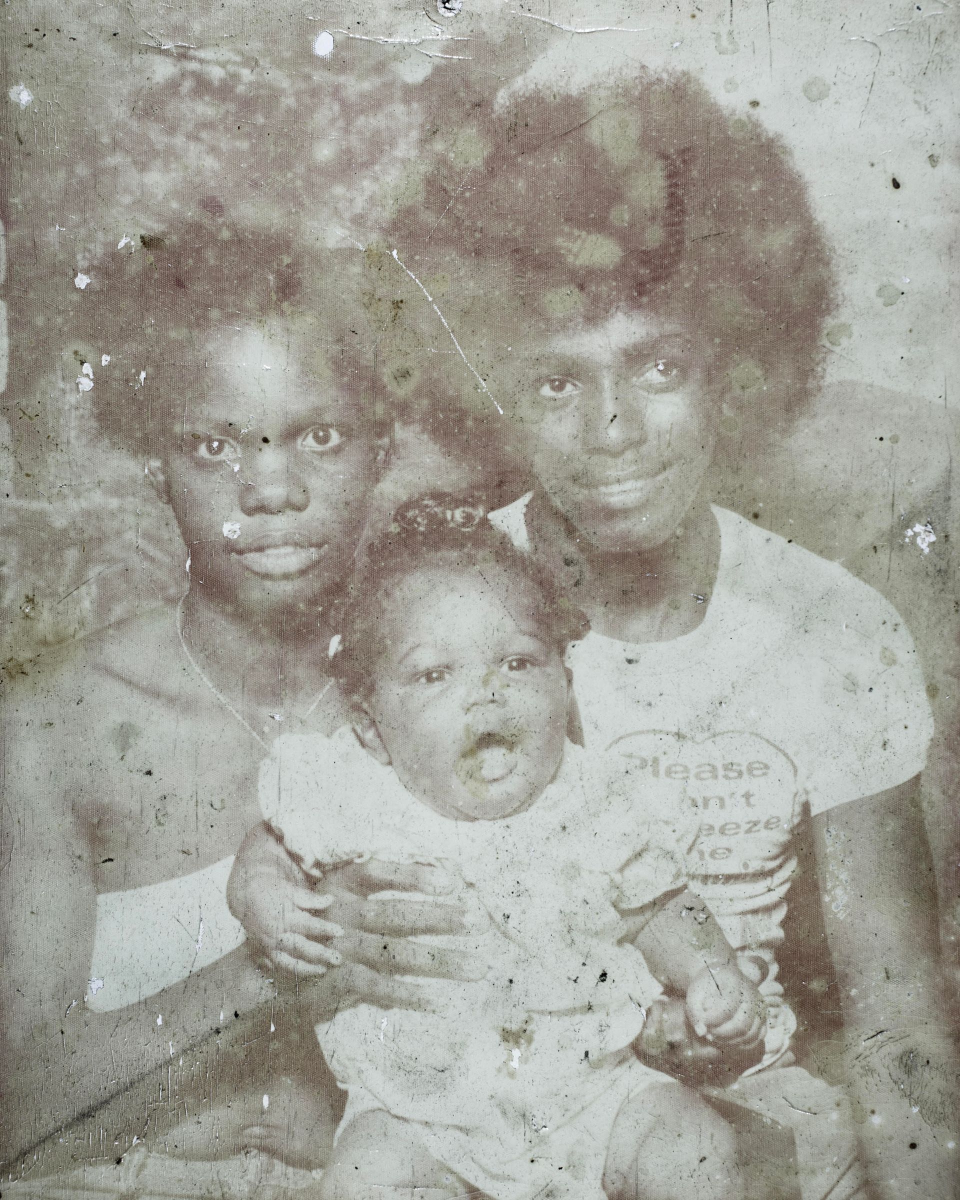 Three children posing together in a faded, black-and-white photo.