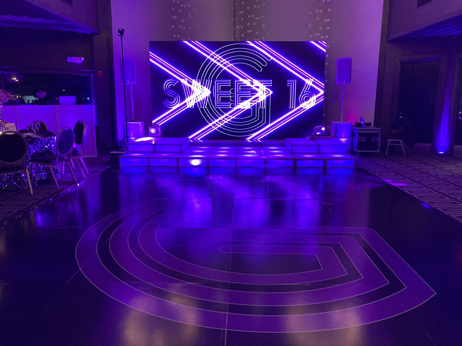 LED Video Wall and A dance floor with purple lights and a large screen behind it