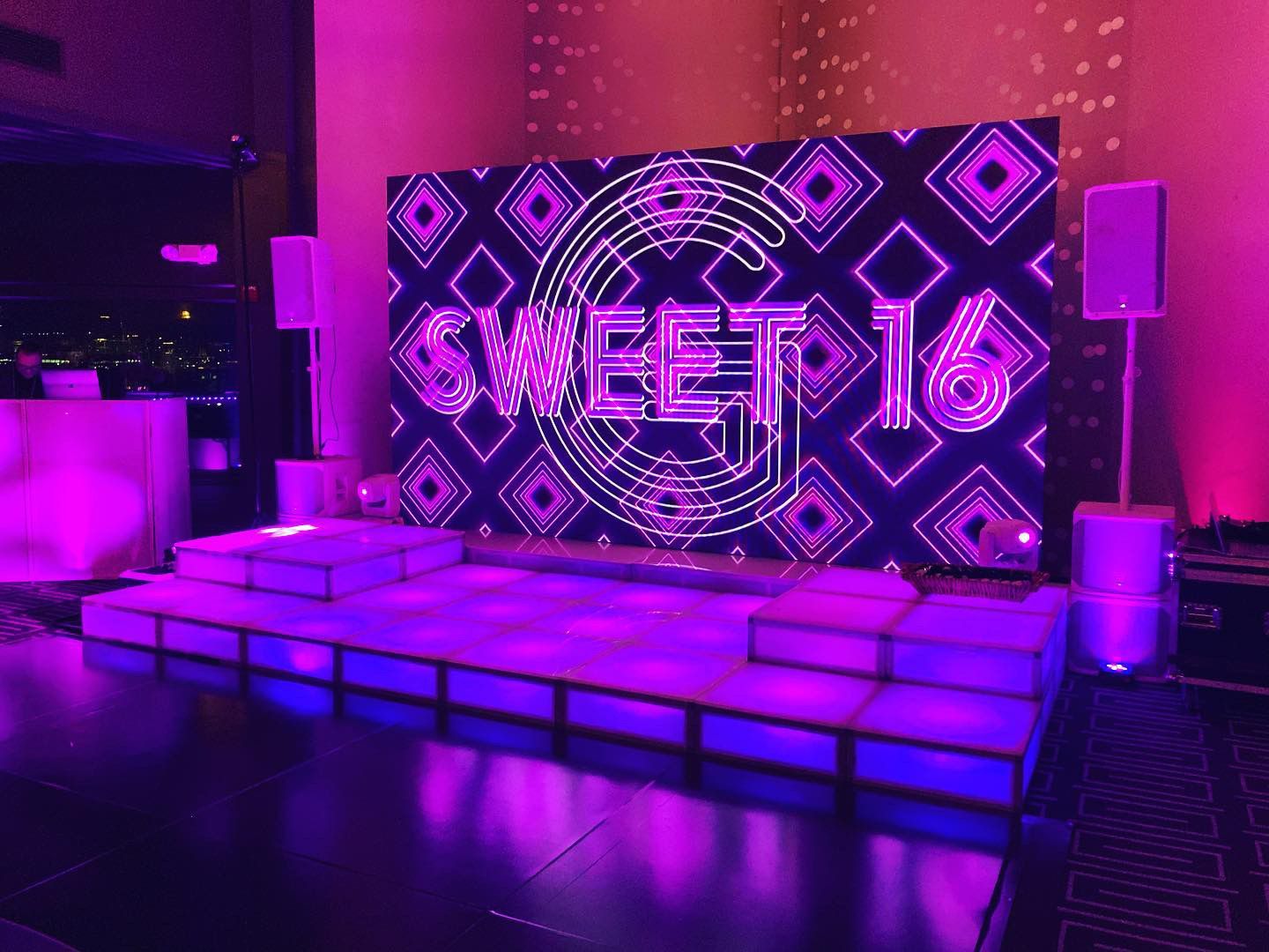 LED Video Wall and A stage with purple lights and a sign that says sweet 16 on it.