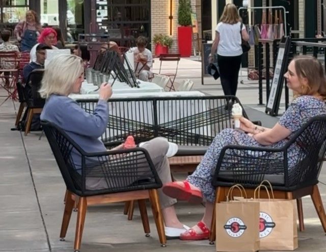 Two people relax with ice cream in a shared seating area at the 5th Street Public Market, surrounded by shops and neighbors. The casual, welcoming setting reflects a neighborhood that becomes part of your everyday rhythm at Gordon Lofts.