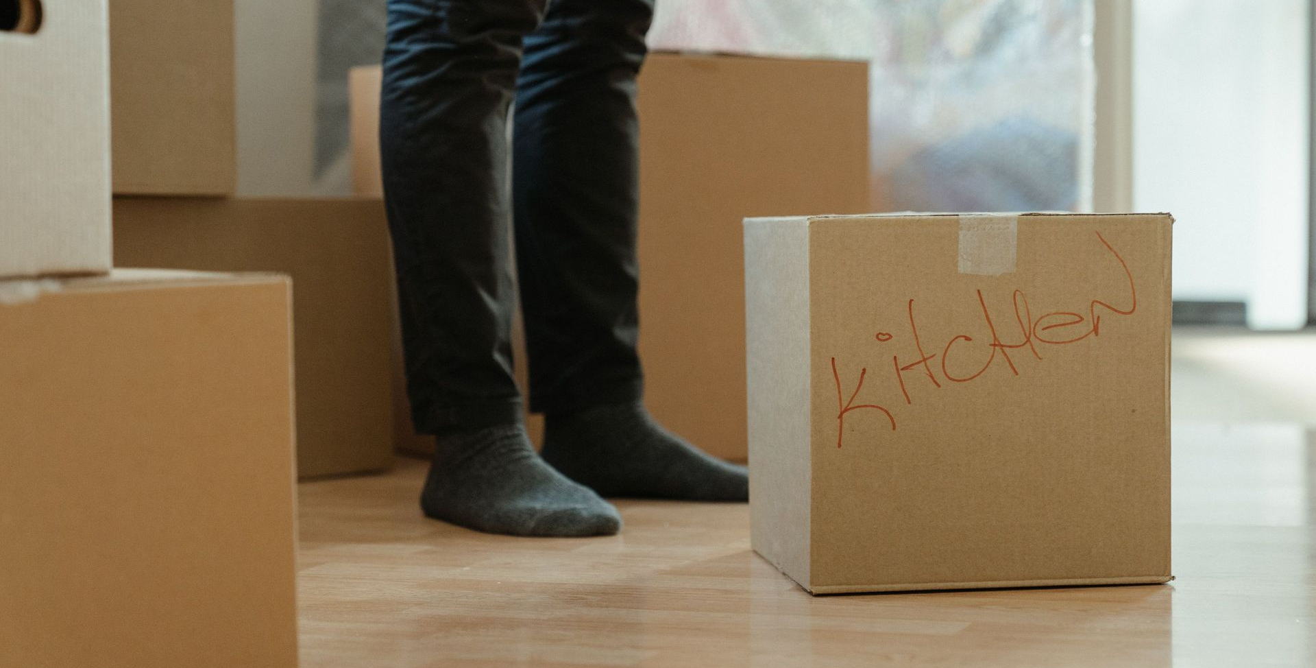 Person unpacking moving boxes into new apartment