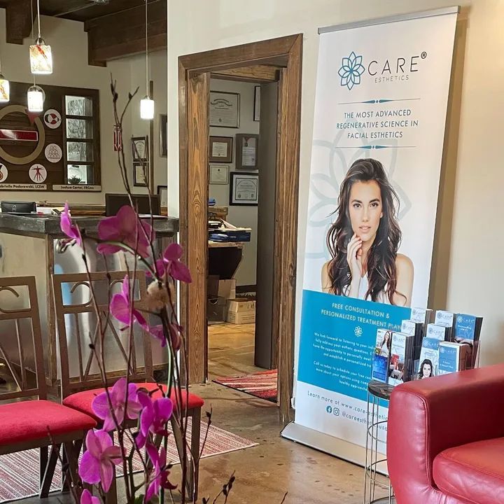 Interior of a wellness office; lobby with a banner, waiting chairs, and door to another room.