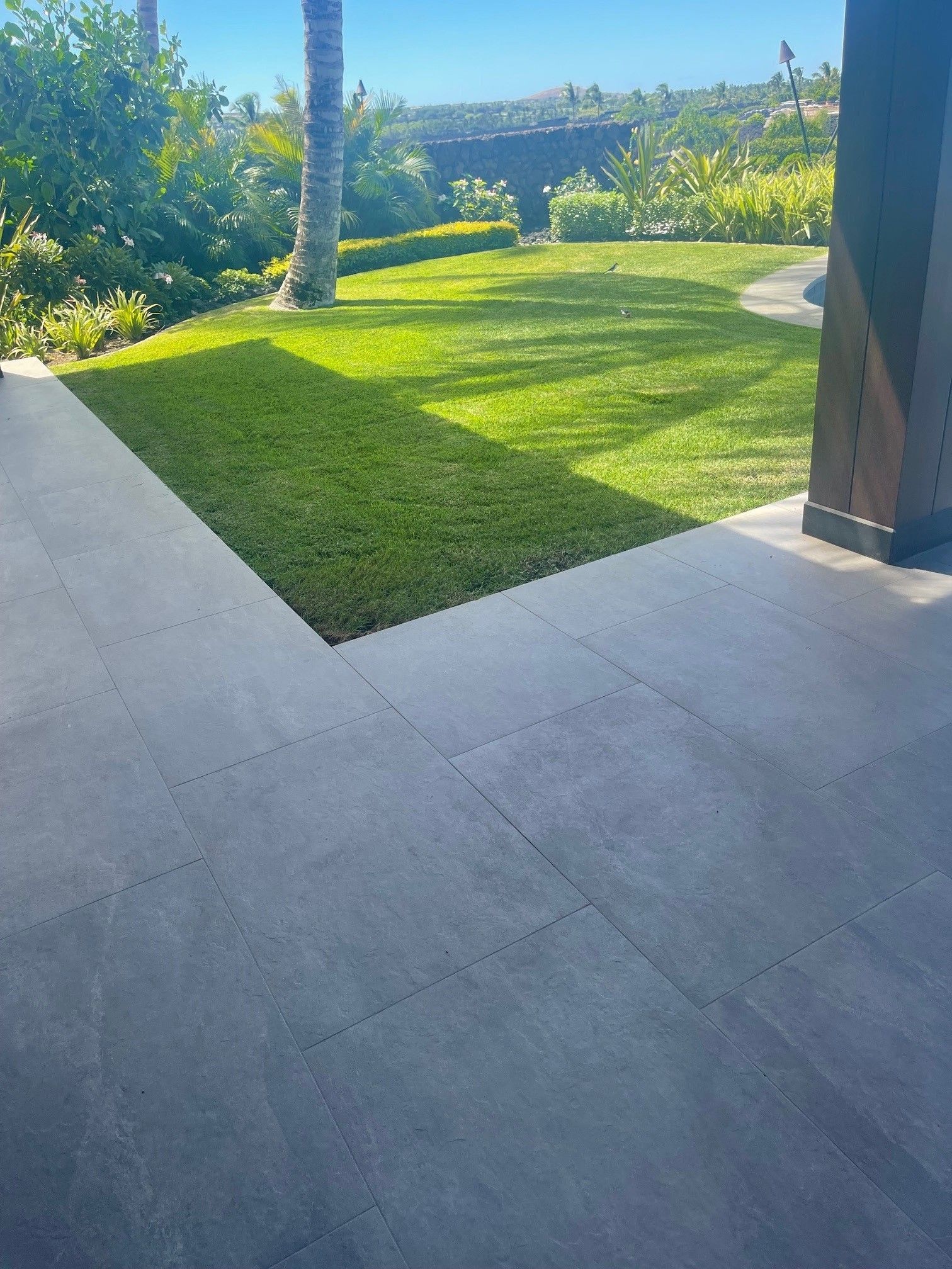 A patio with a view of a lush green lawn