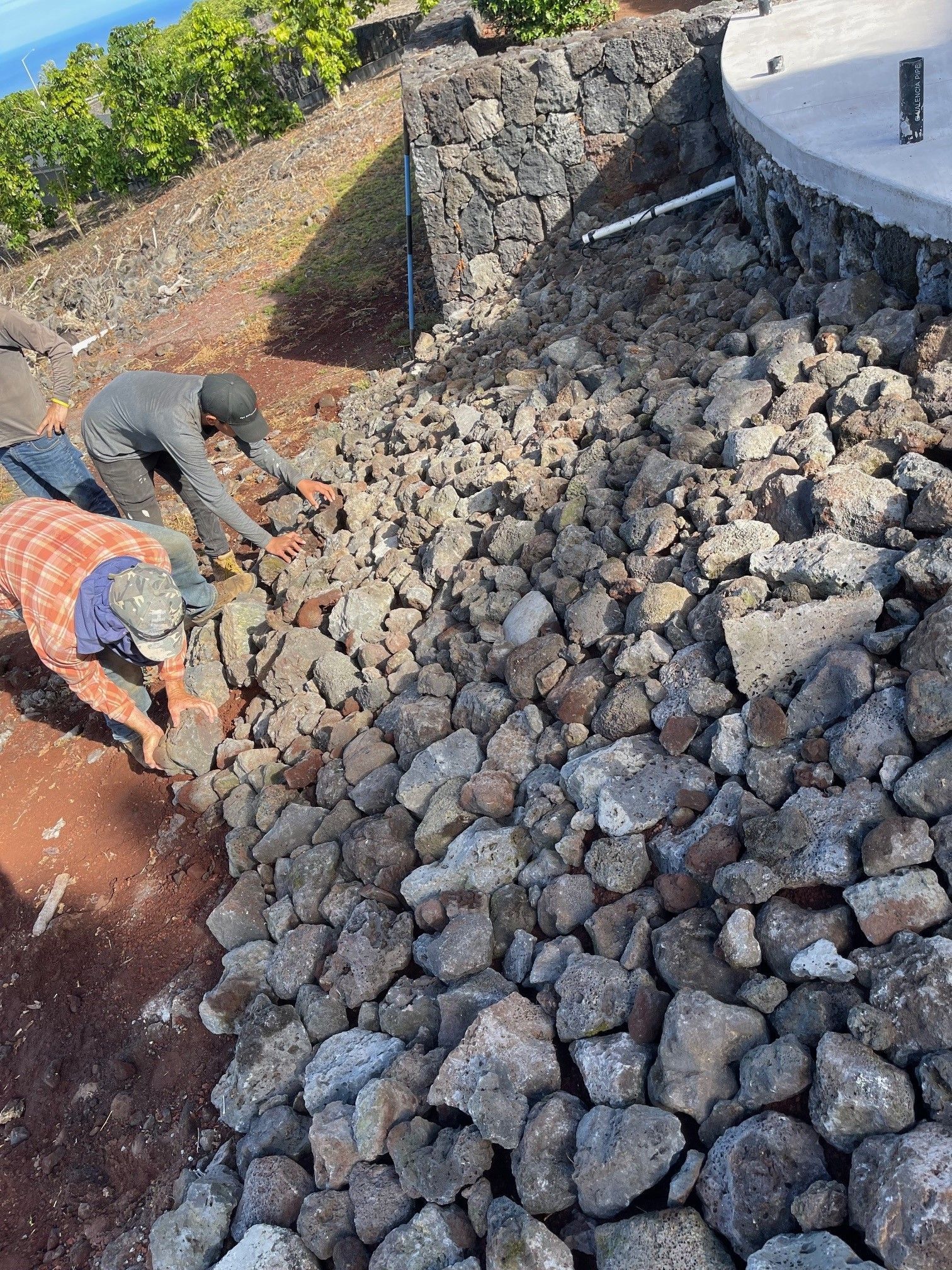 A group of people are working on a pile of rocks
