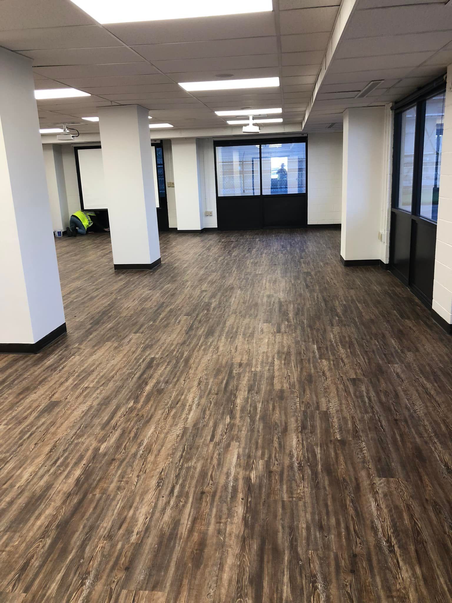 A large room with a wooden floor and white walls.
