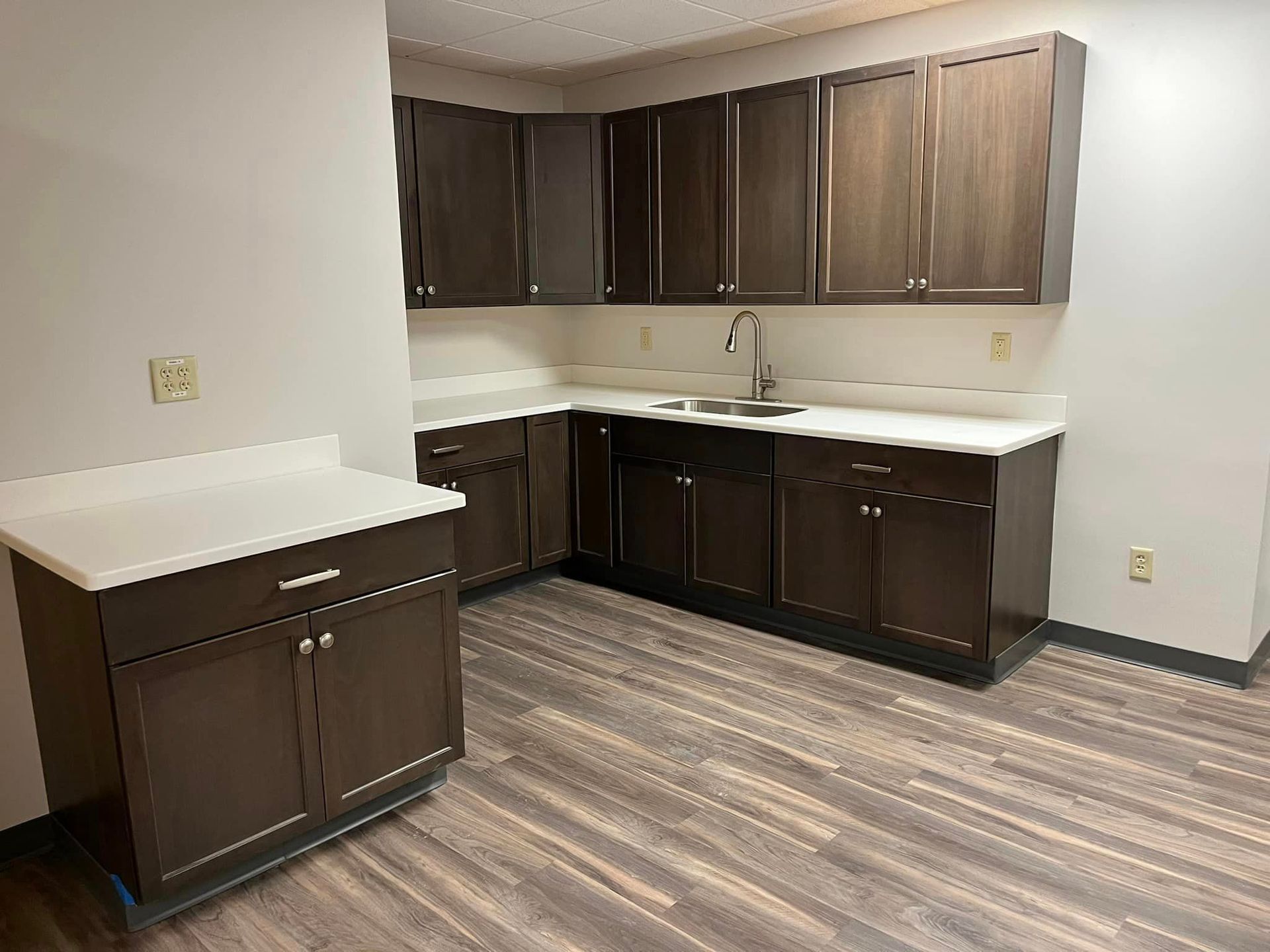 A kitchen with wooden cabinets and a sink.