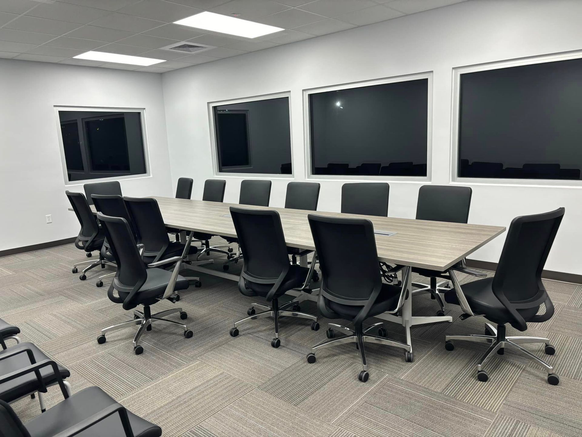 A conference room with a long table and chairs.