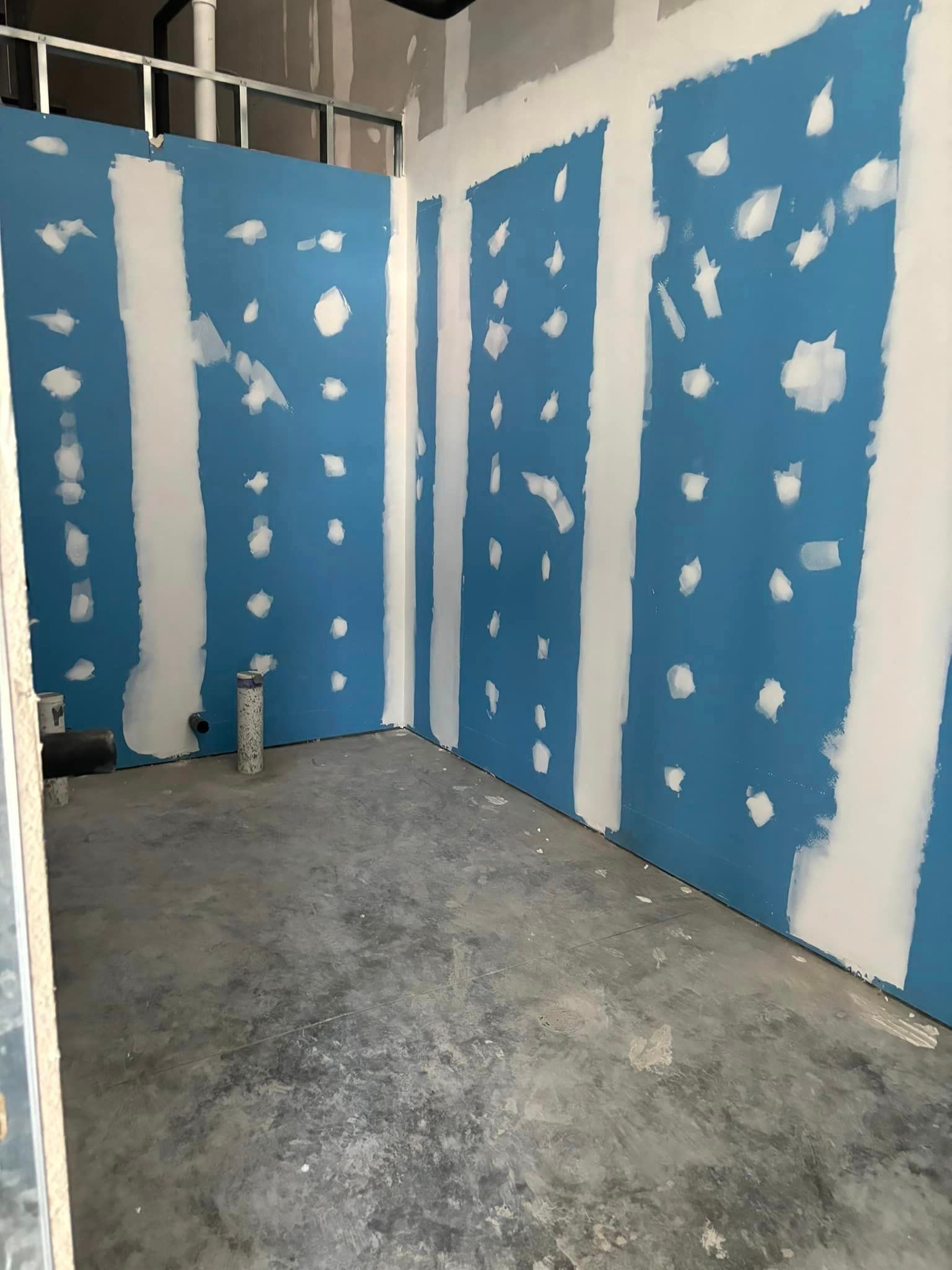 A room with blue and white walls and a concrete floor