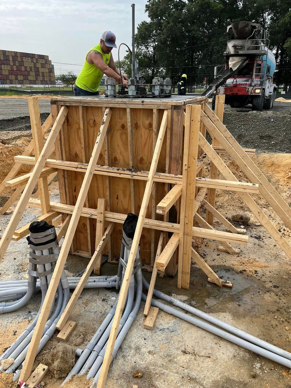 A man is working on a wooden structure at a construction site.