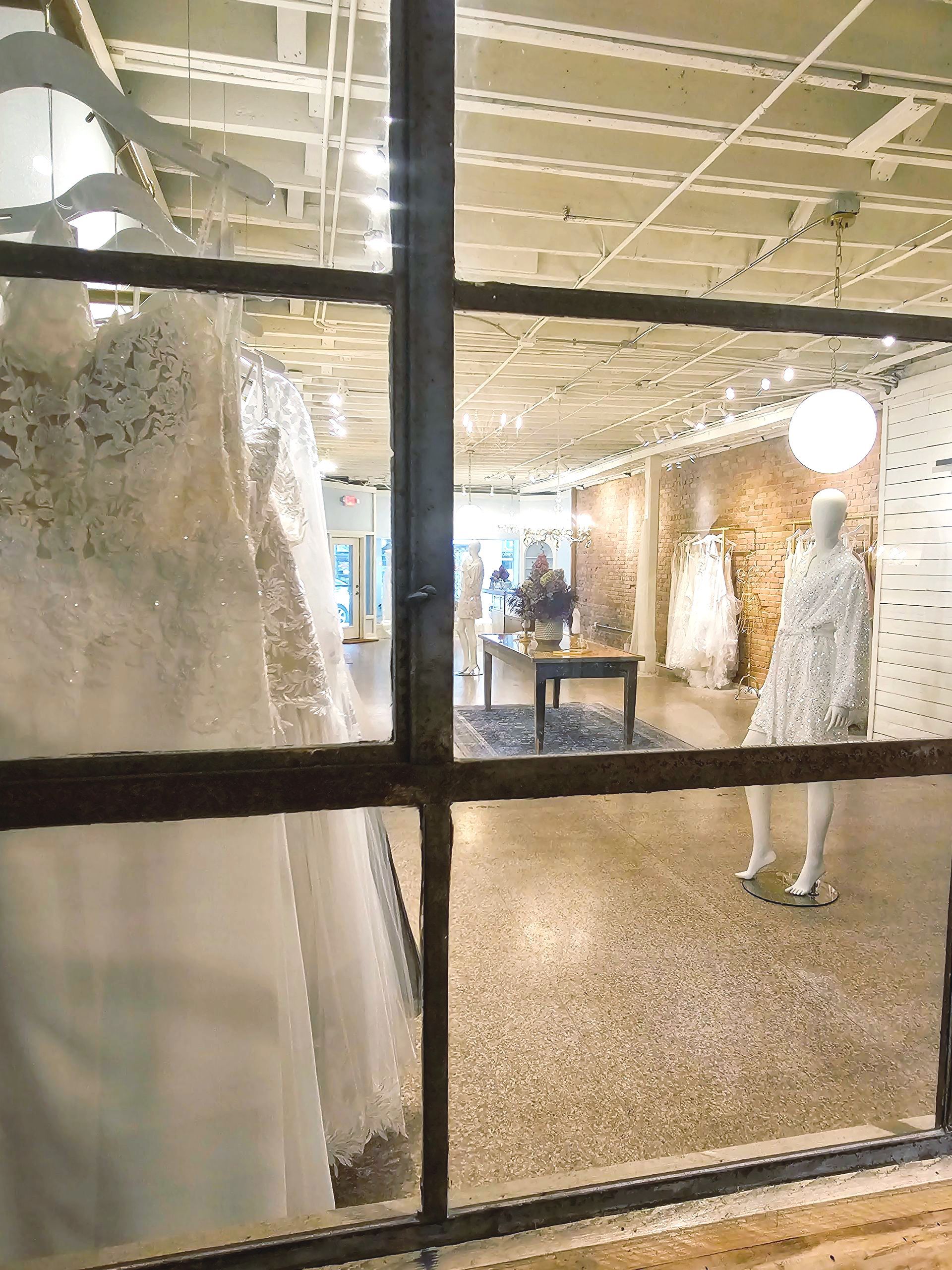 A window display of wedding dresses in a store.