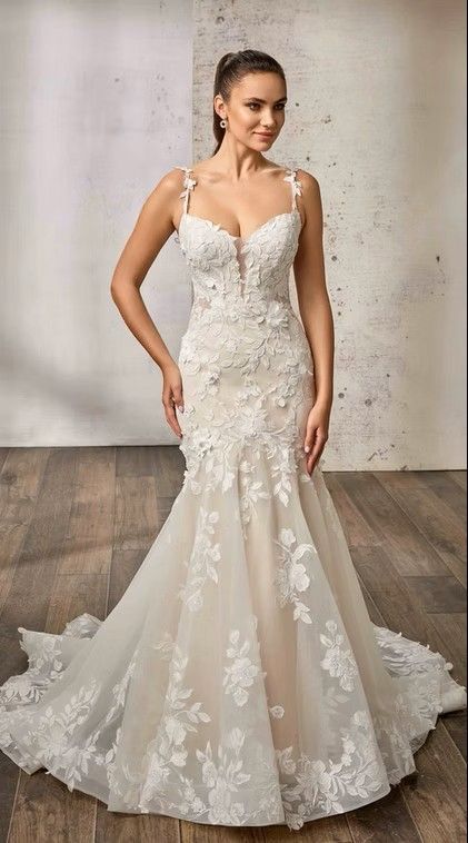 Woman in a white lace wedding gown posing against a neutral studio backdrop. Benedetta - DR2655