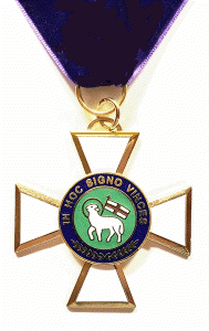 Gold and blue medal with a circular emblem and a white lamb, hanging from a dark ribbon.
