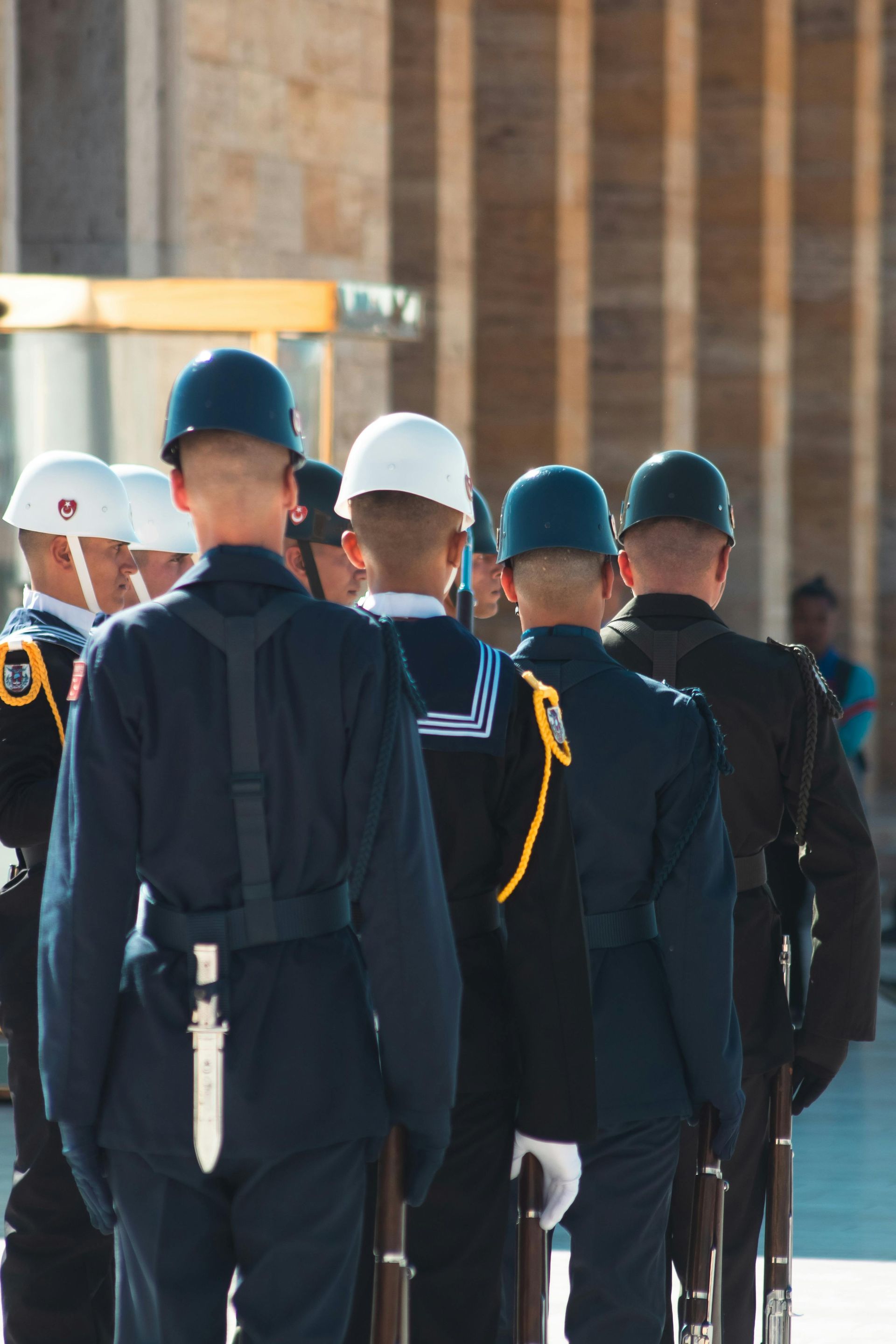 Uniformed guards in white and blue helmets standing in formation indoors