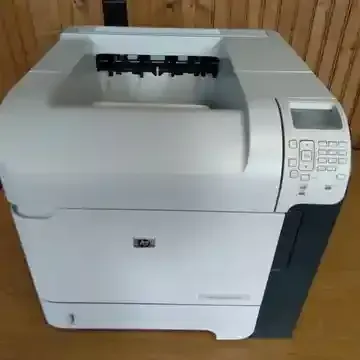 An hp printer is sitting on a wooden table.