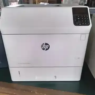 A white hp printer is sitting on a table.