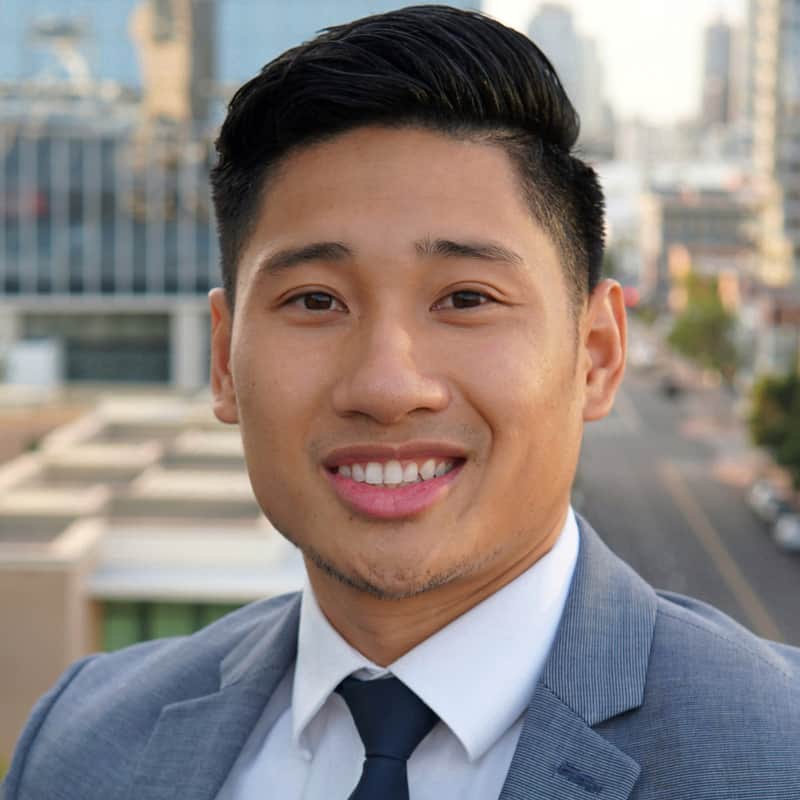 A man in a suit and tie is smiling for the camera.