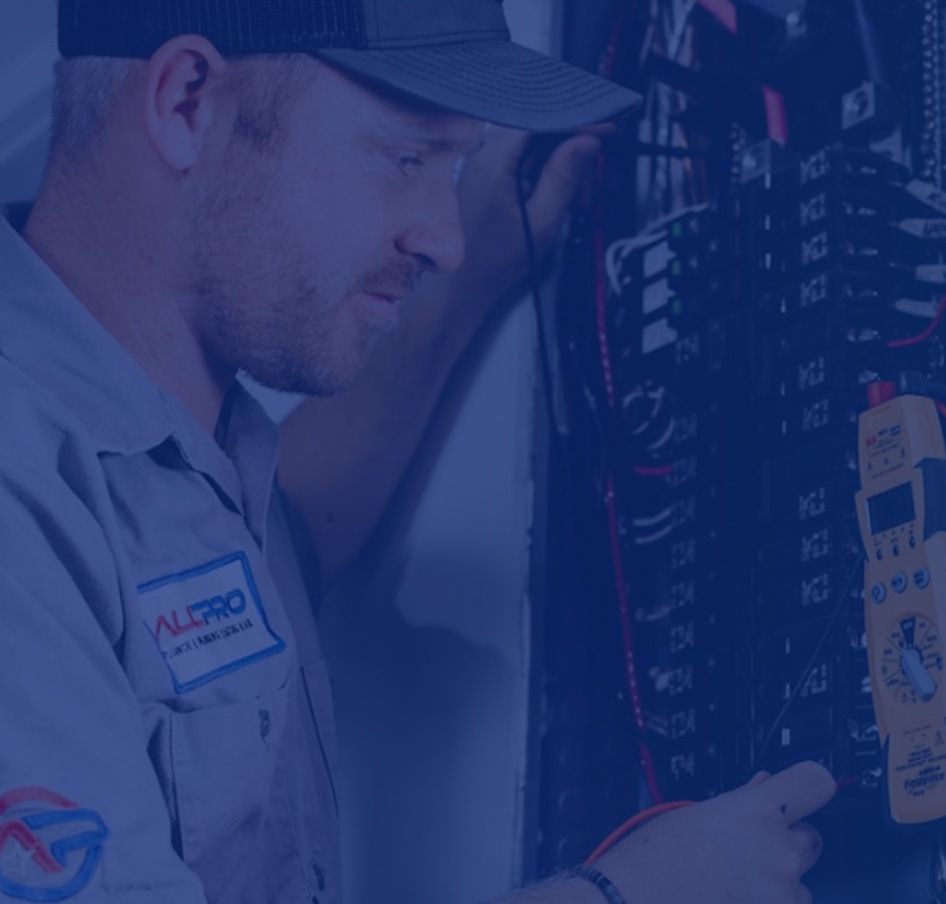 Electrician in blue work shirt, inspecting an electrical panel, focused expression. Electrician in blue work shirt, inspecting an electrical panel, focused expression.