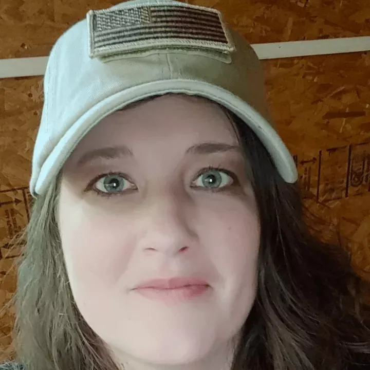 Lisa Weaver Close-up of a person wearing a light gray cap and looking at the camera indoors.