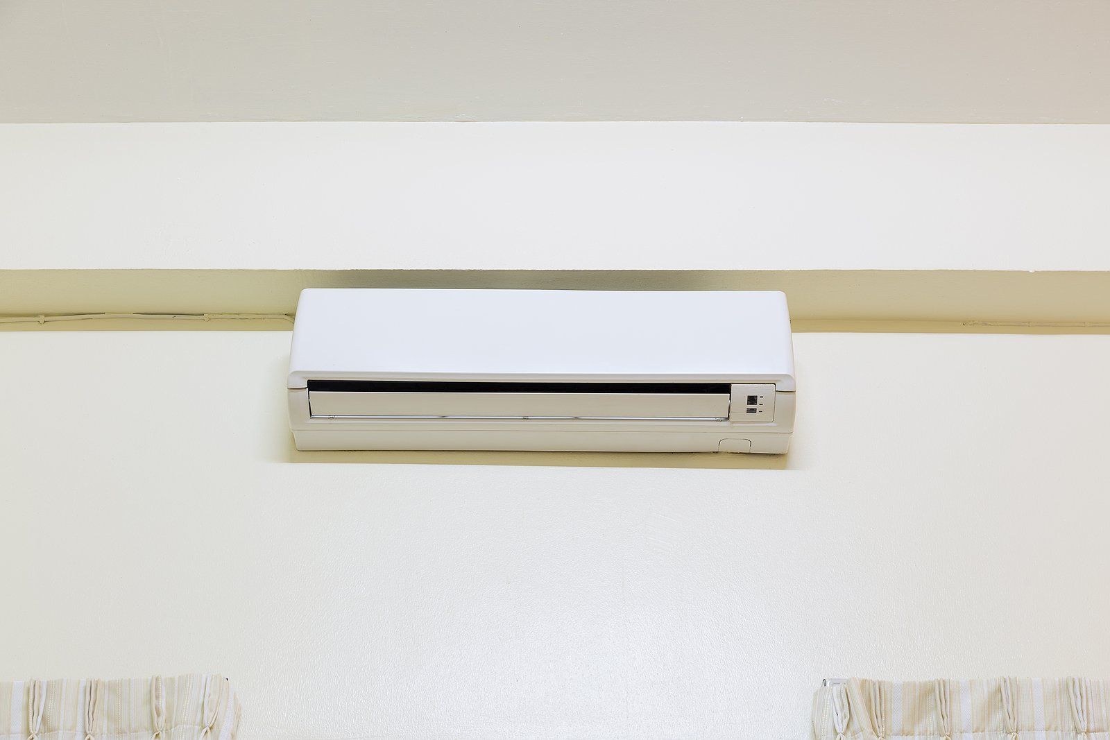 Mini Split Installers Near You Wall-mounted white air conditioner centered on a cream-colored wall