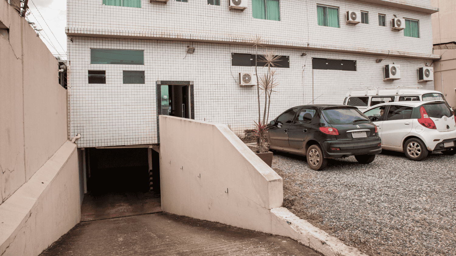 Um grupo de carros está estacionado em frente a um prédio.