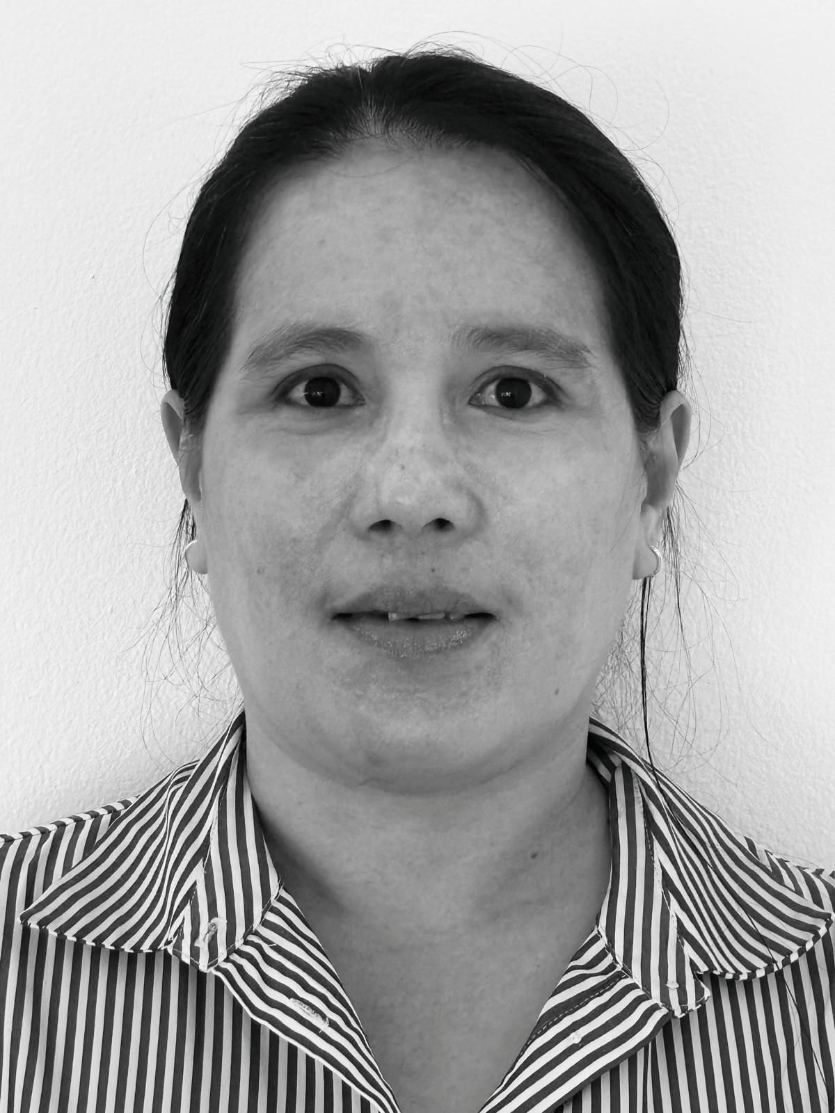 A black and white photo of a woman wearing a striped shirt and earrings.