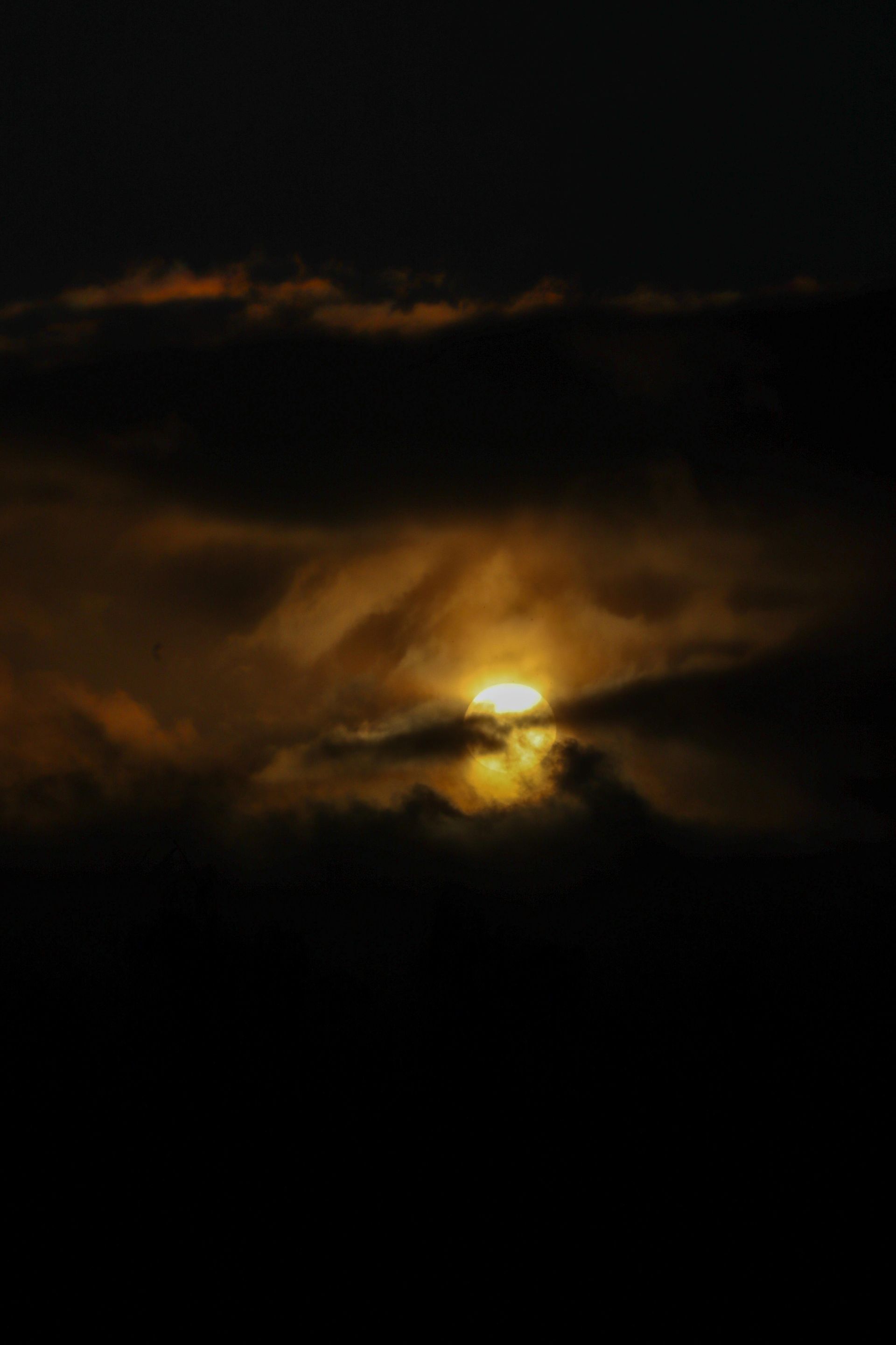 Sun peaking through a dark cloud sky