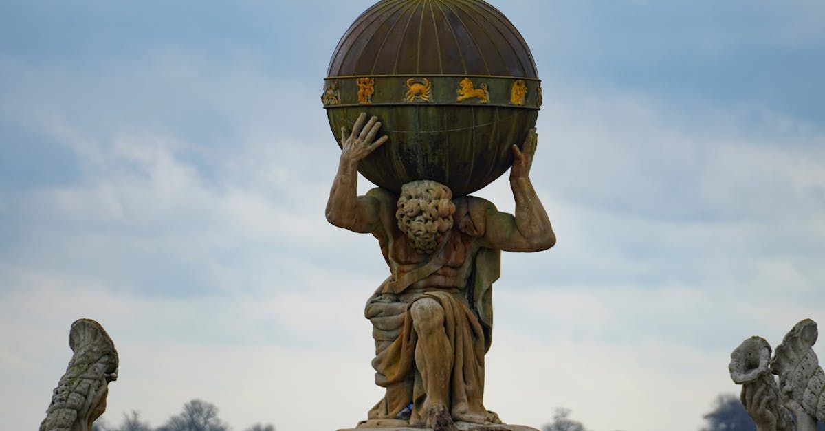 Statue of Atlas, a man carrying a globe, against a cloudy sky.