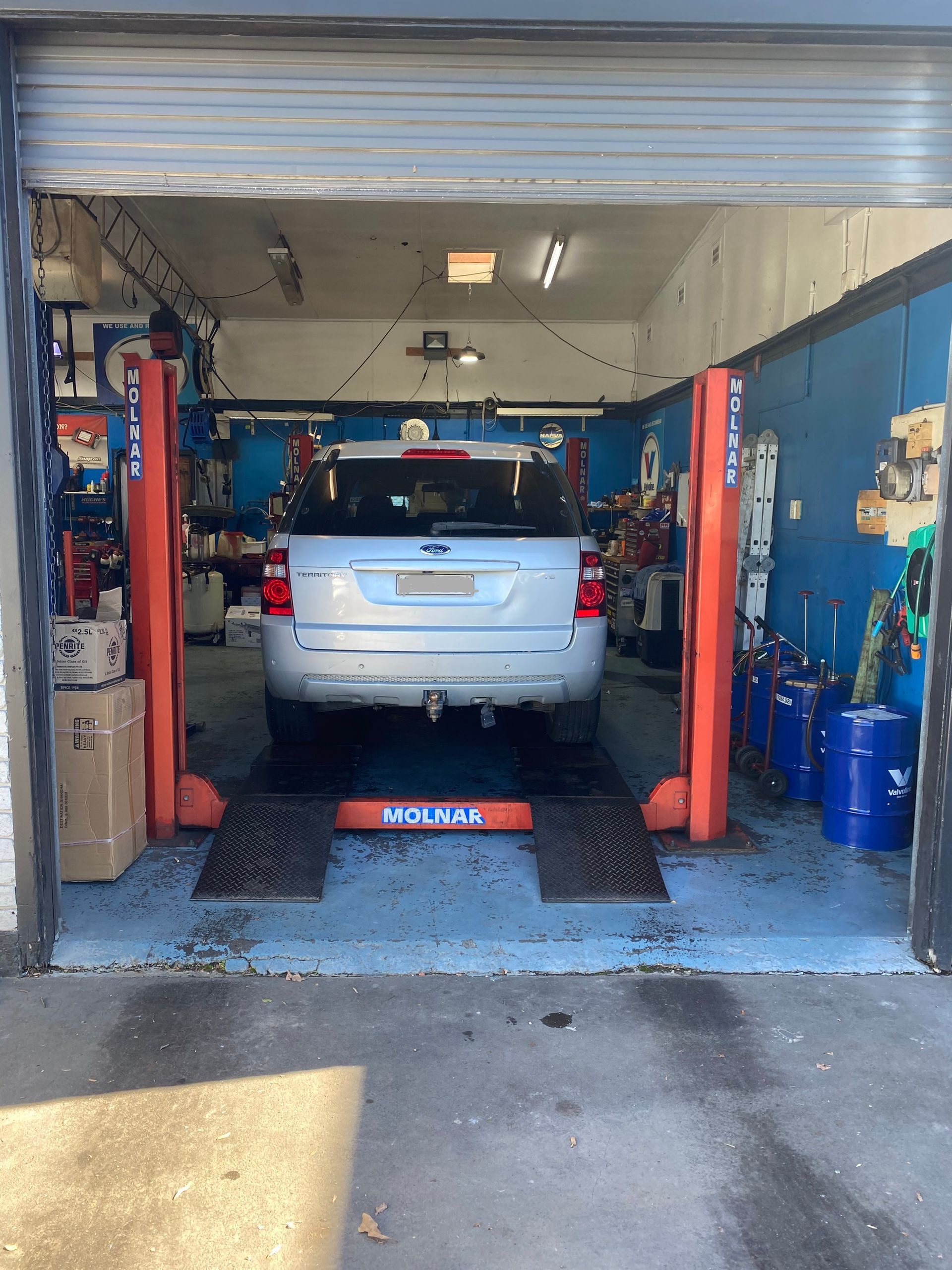 White SUV in a Garage Bay With Tools and Equipment — M T Automotive In Wallsend, NSW