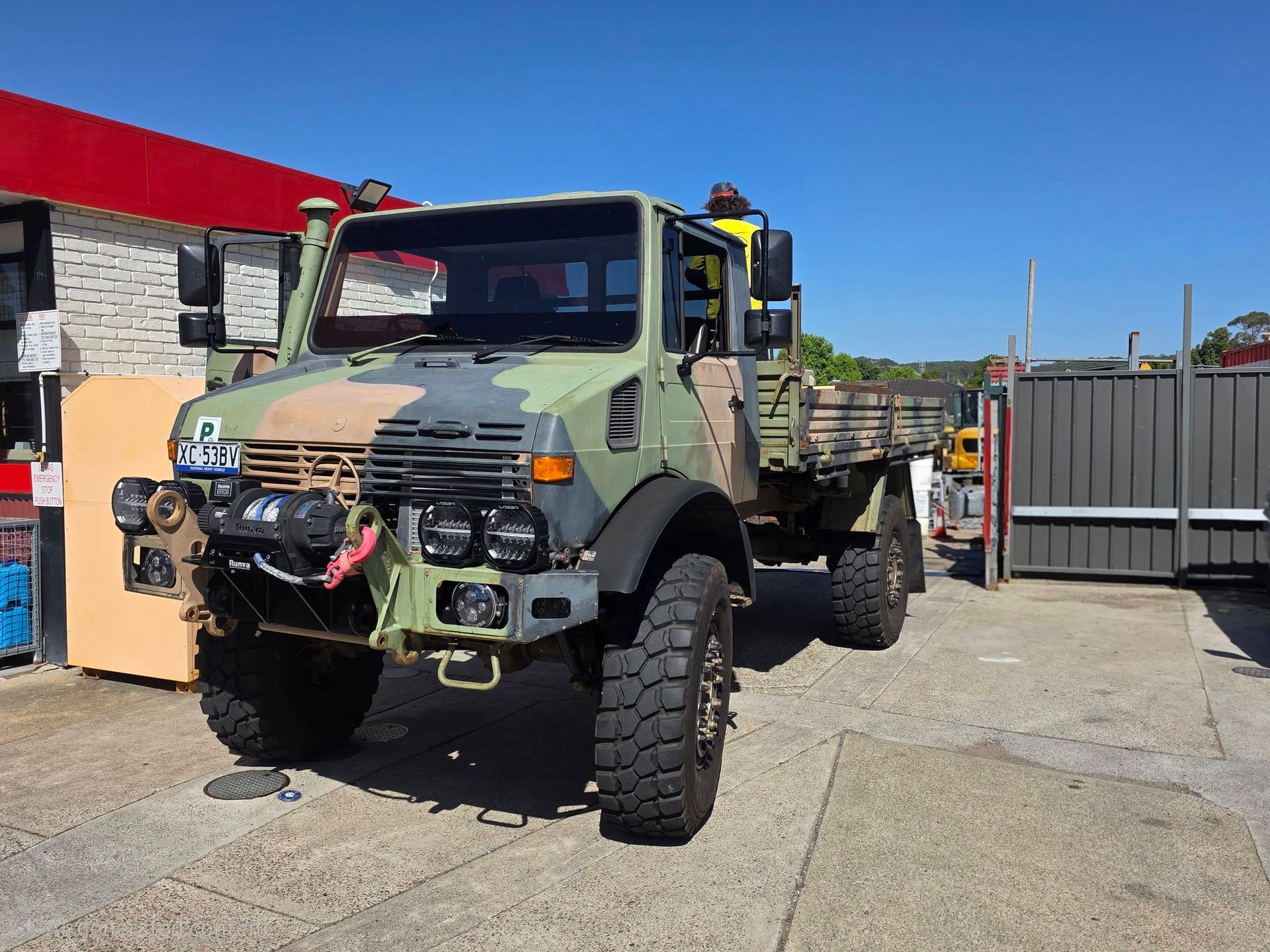 Military Style Camouflaged Truck Parked Outdoors Beside a Building — M T Automotive In Wallsend, NSW