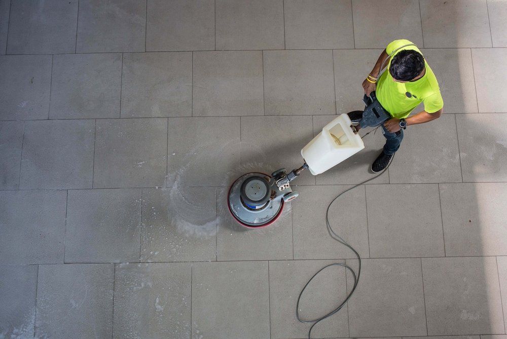 A Top View of A Man Cleaning Floor with Machine — Total Sealing Works Whitsundays in Bundaberg, QLD
