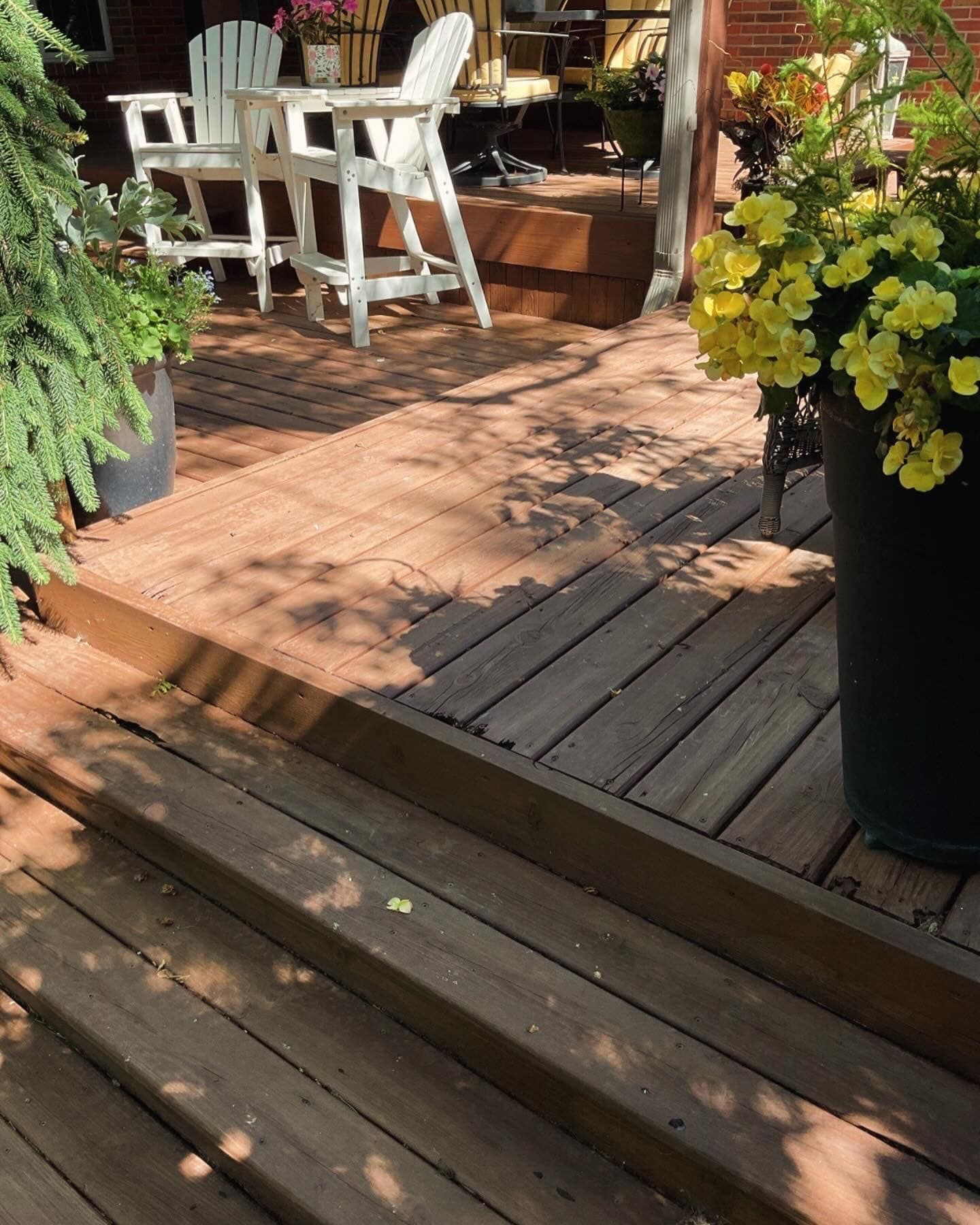 A wooden deck with chairs and flowers on it