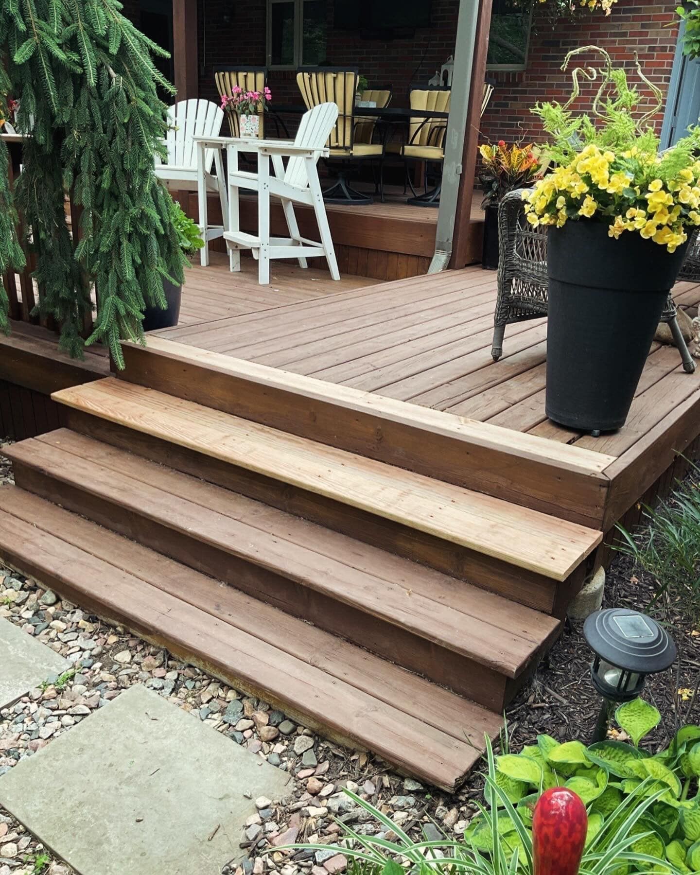 A wooden deck with stairs and chairs on it