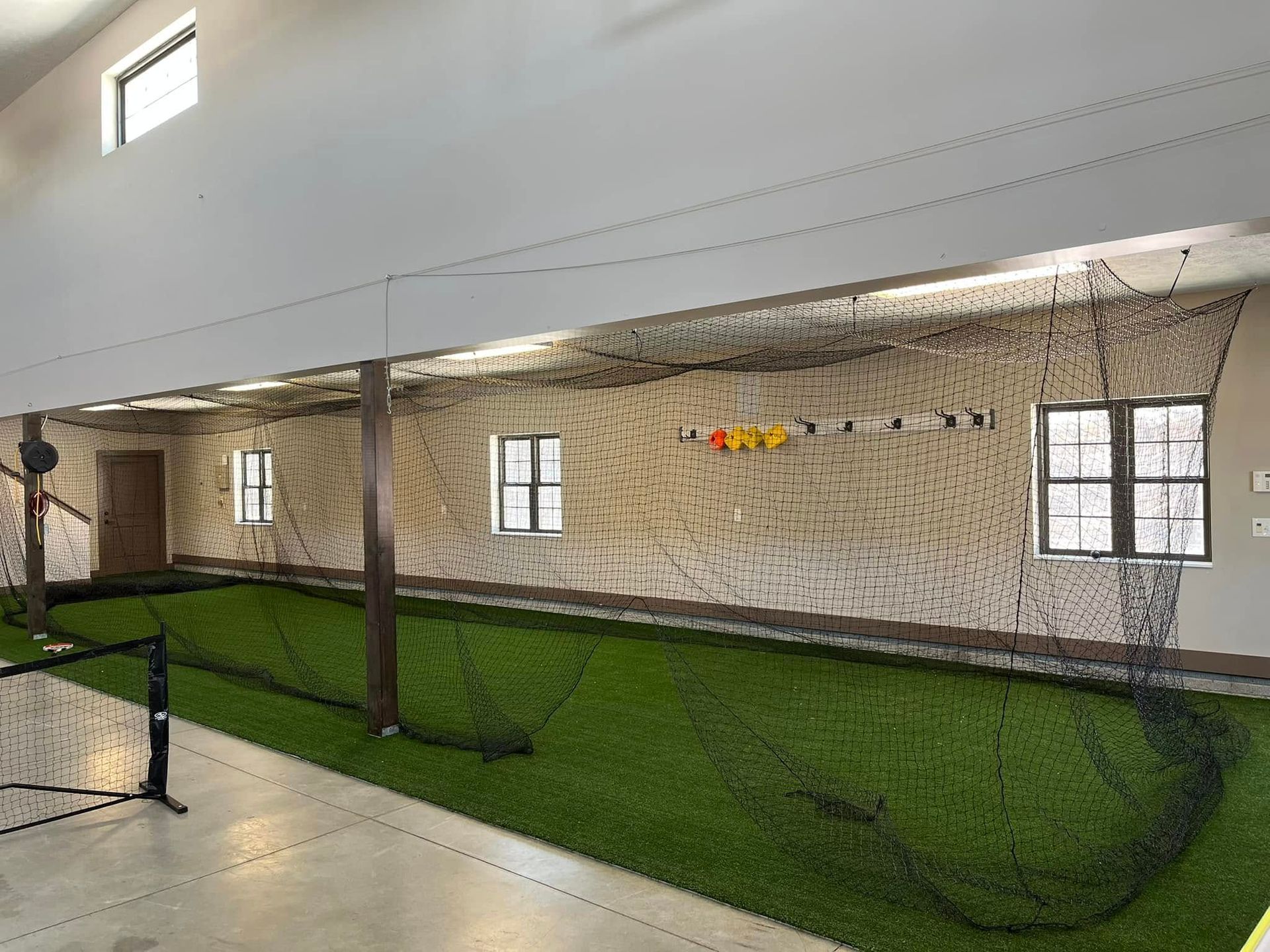 A large room with a lot of grass and a brick wall.