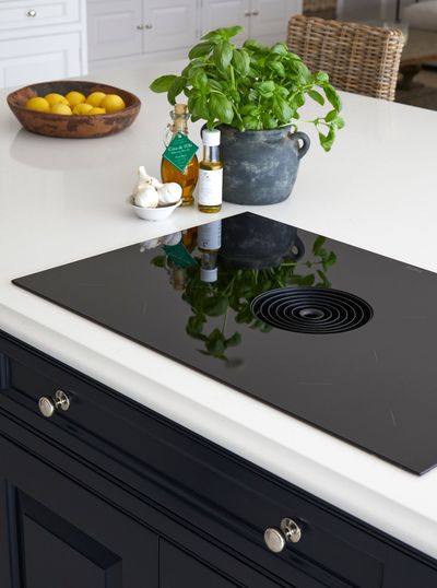 a bottle of garlic oil sits on a counter next to a potted plant